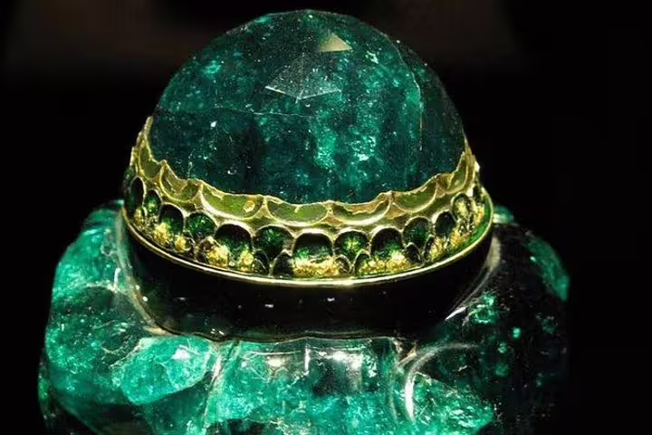 Magnificent emerald crown jewel with gold detailing showcased at the Imperial Treasury in Vienna.