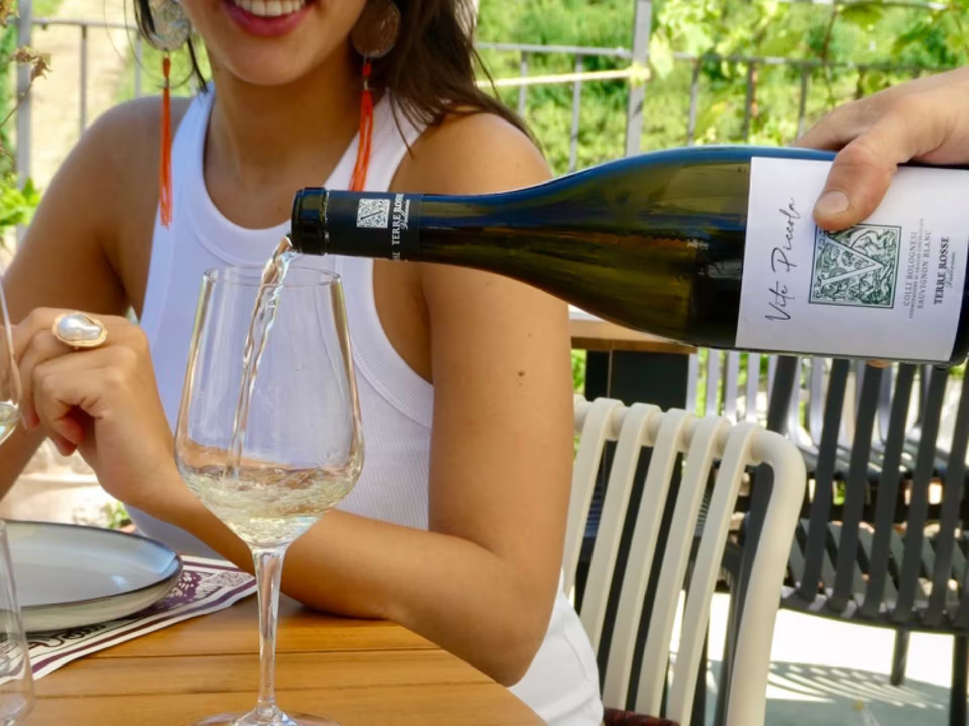 Pouring Emilia-Romagna white wine during boutique winery tour in Bologna with tasting on terrace