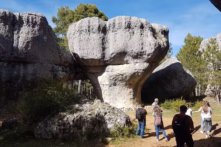 Hikers explore mushroom-shaped rocks in the Enchanted City on a day trip from Cuenca, Spain