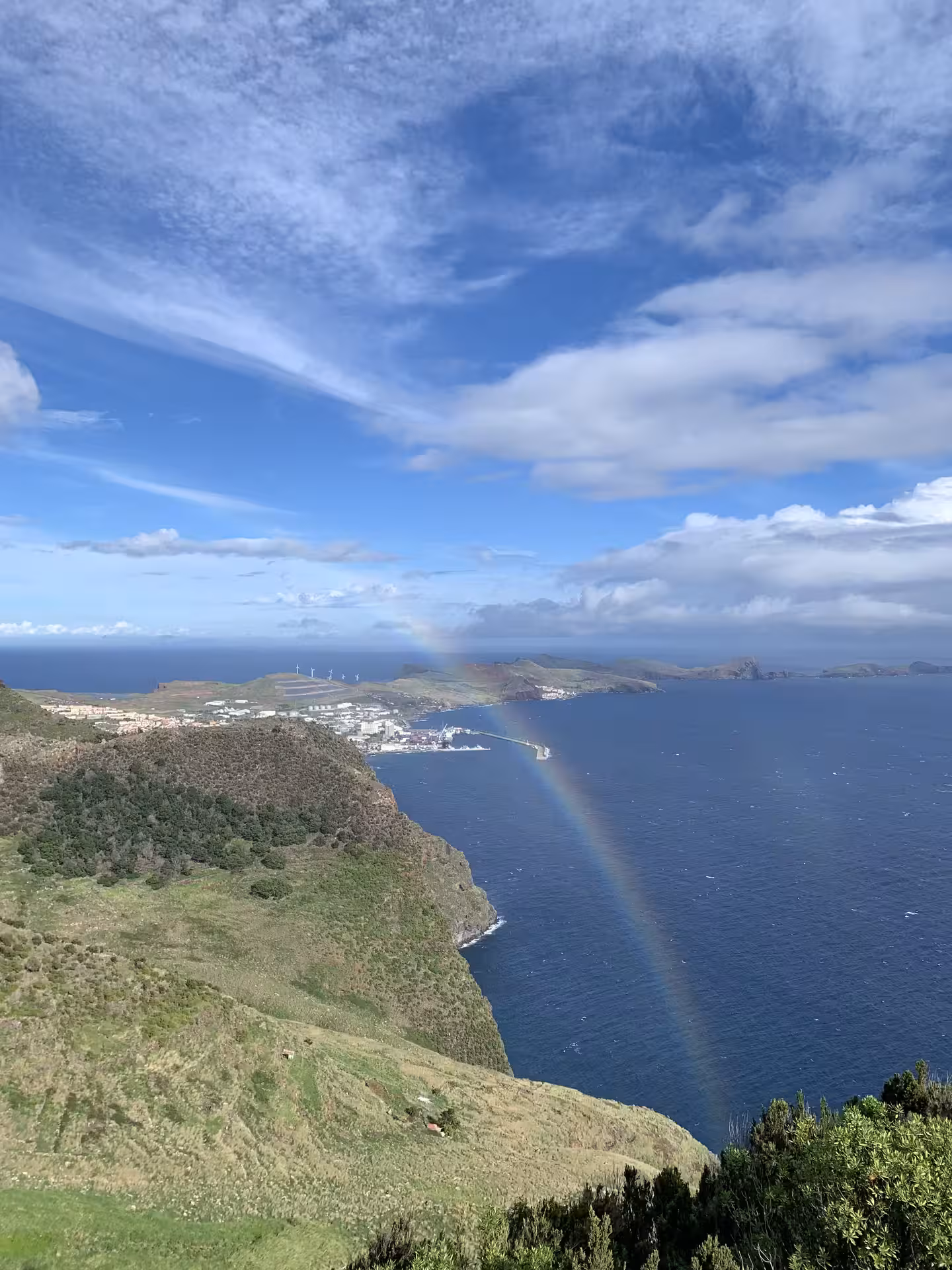 Majestic rainbow arching over coastal landscape with ocean views on The Enchanted East Tour.