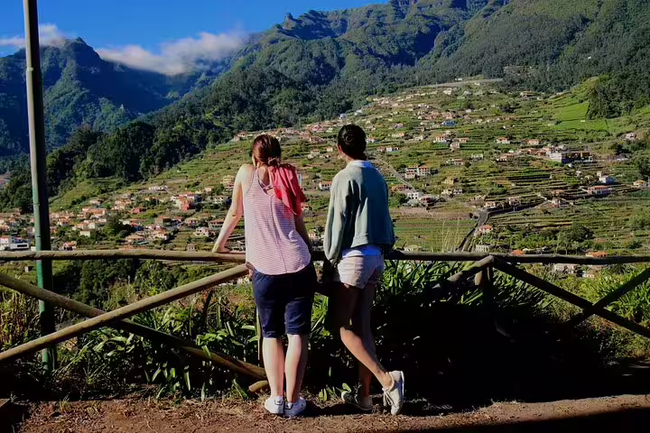 Two tourists enjoy stunning vineyard views on the Enchanted Vineyards 4x4 Tour near Cabo Girão sea cliff in Madeira.