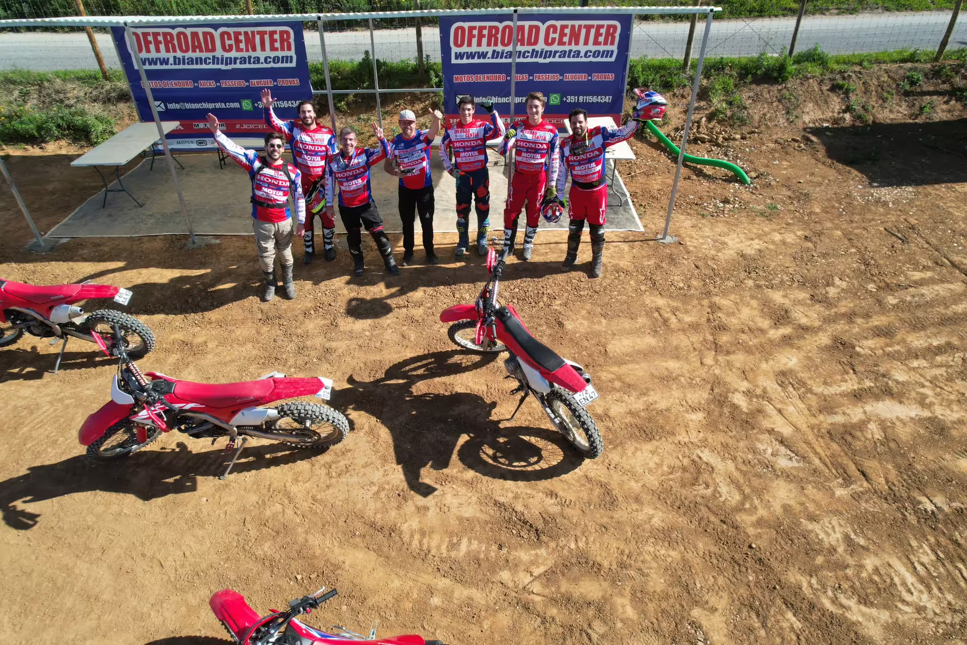 Aerial view of riders and red dirt bikes ready for First Ride Enduro Experience at Offroad Center in Carregado, Lisbon.