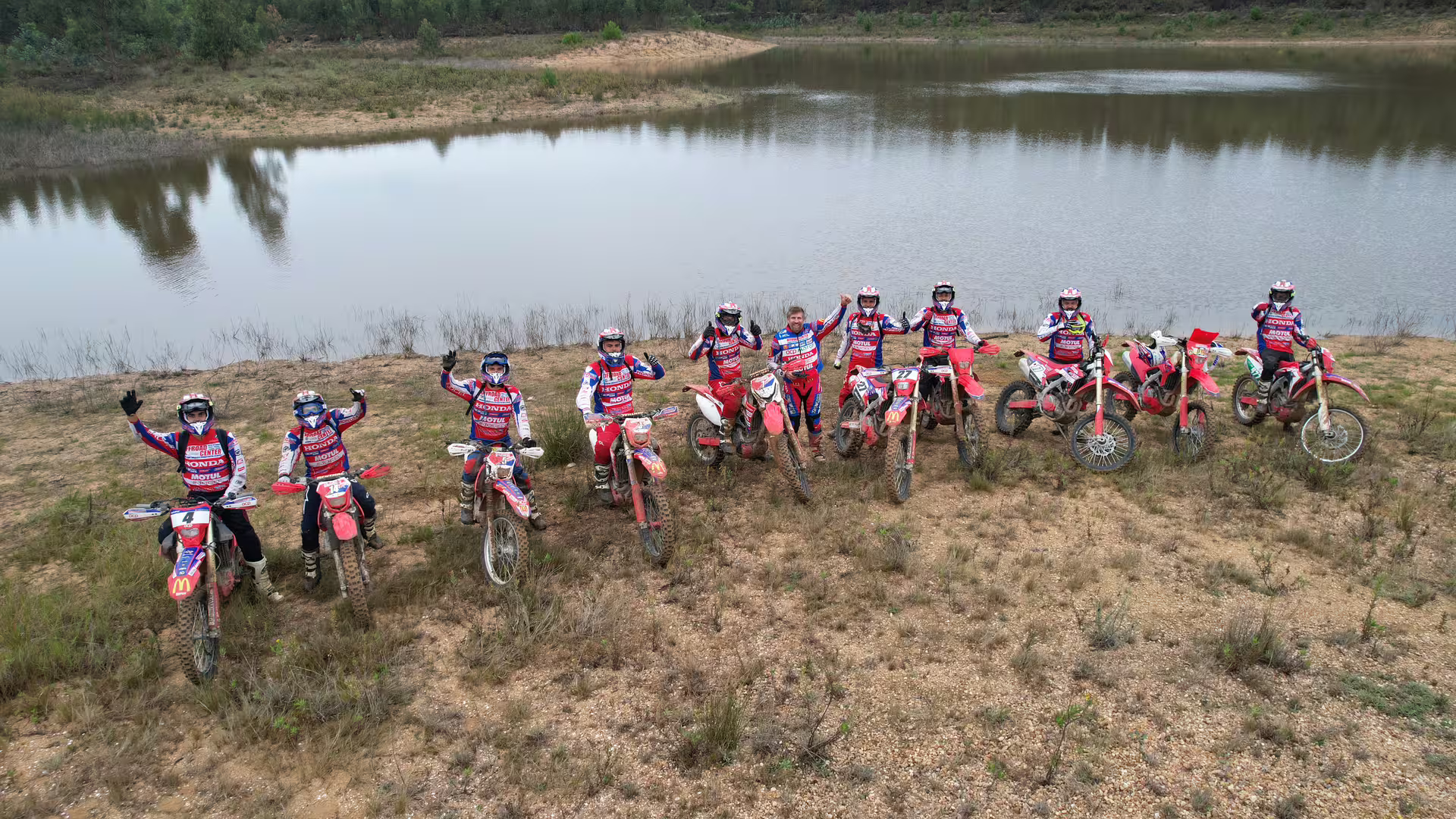 Group of enduro riders by a scenic lake during a 3-hour tour in Carregado, Lisbon, showcasing off-road adventure.