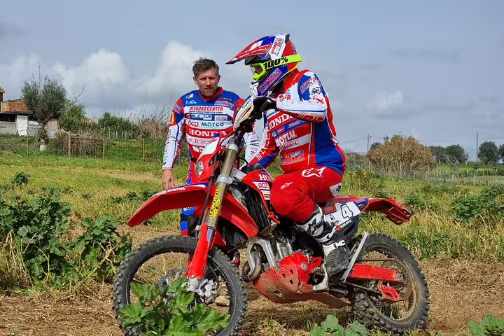Enduro rider receives guidance on dirt trail in Carregado, Lisbon, highlighting exciting off-road training session.