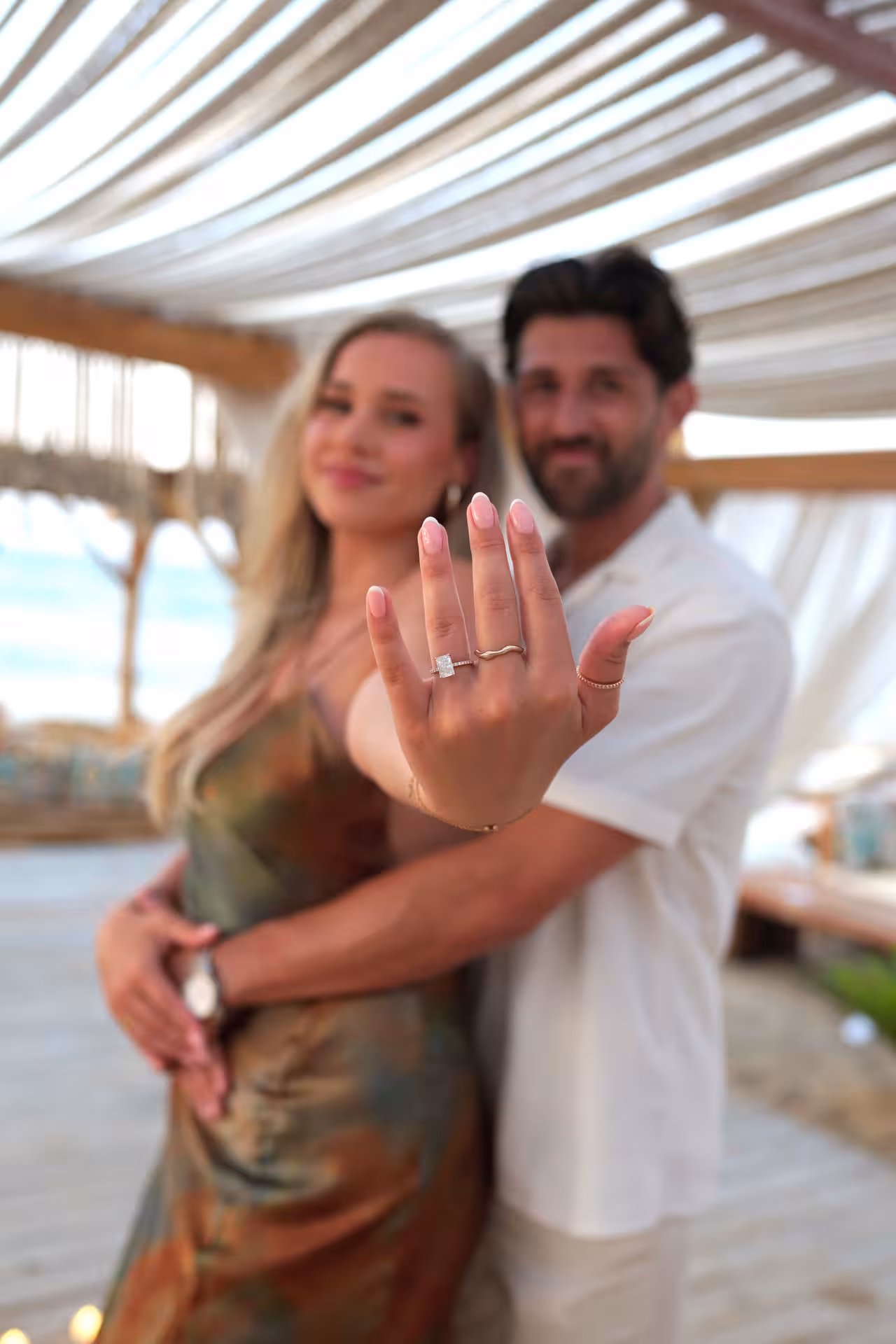 Engaged couple celebrating at Heraklion Venetian Port, showcasing a sparkling engagement ring with a joyful embrace.