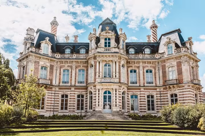 Grand French château with ornate Baroque facade, mansard roof, and manicured gardens in Epernay