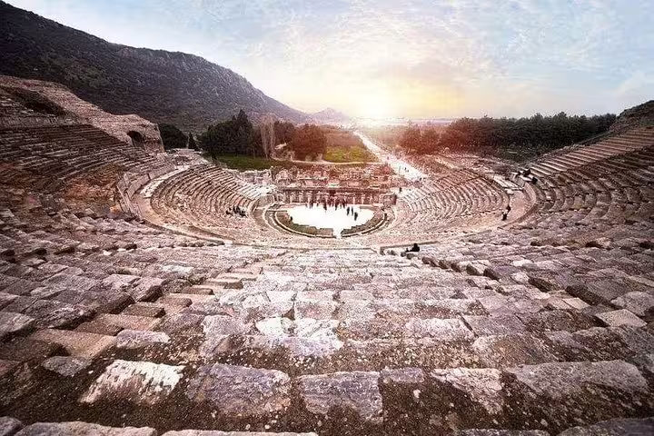 Experience the grandeur of the ancient Ephesus amphitheater with a breathtaking view of the surrounding landscape at sunset.