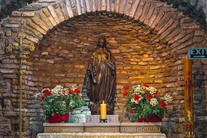 Intricate statue surrounded by flowers inside the ancient chapel on the Ephesus private tour from Kusadasi Port.