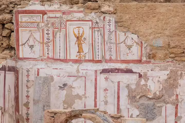 Ancient frescoes in Ephesus depicting intricate designs, ideal for Kusadasi shore excursions.