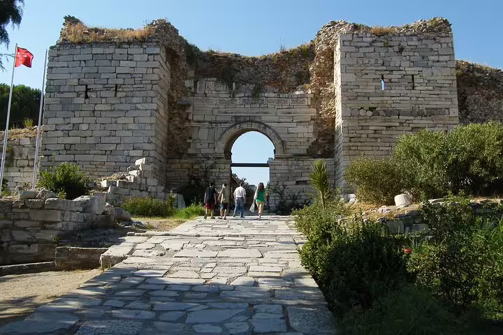 Visitors enter the ancient gate at Ephesus on a private all-inclusive tour with St. John Basilica and lunch