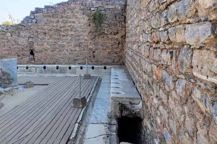 Ancient latrine area at Ephesus ruins, a highlight on 4–6 hour private or group tour with no hidden fees