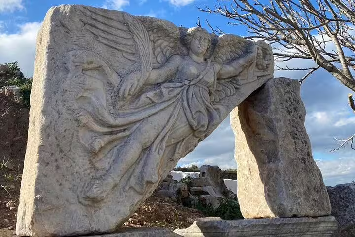 Winged relief carving at ancient Ephesus ruins, a highlight of private half-day tour with on-time return