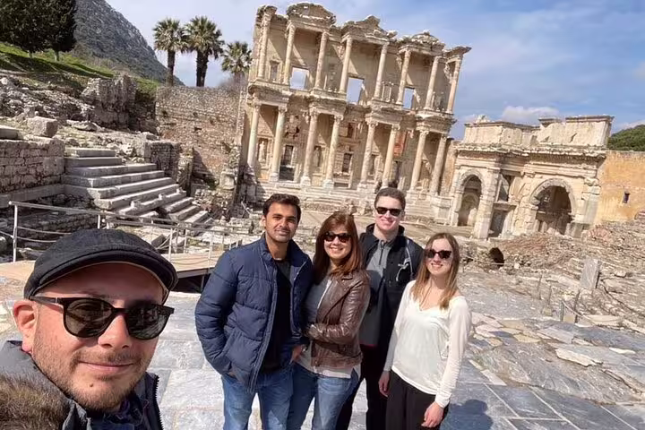Visitors pose in front of the historic Celsus Library during a private Ephesus tour from Izmir Port, showcasing ancient ruins.