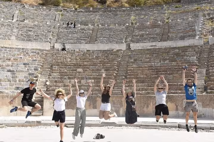 Visitors jumping inside the Great Theatre of Ephesus, fun stop on Biblical Ephesus and St John tour for cruisers