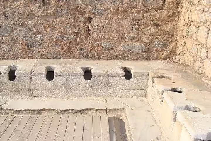 Discover the historical public latrines of Ephesus, a unique archaeological site on the half-day tour from Kusadasi hotels.