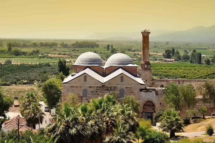 Explore the historic İsa Bey Mosque amidst lush greenery on the Ephesus Private Tour from Izmir Port.