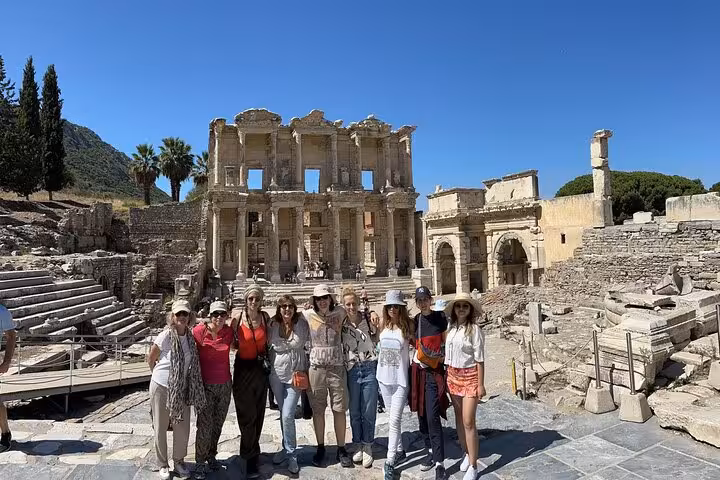 Visitors posing by the Library of Celsus ruins in Ephesus on a full-day tour from Bodrum