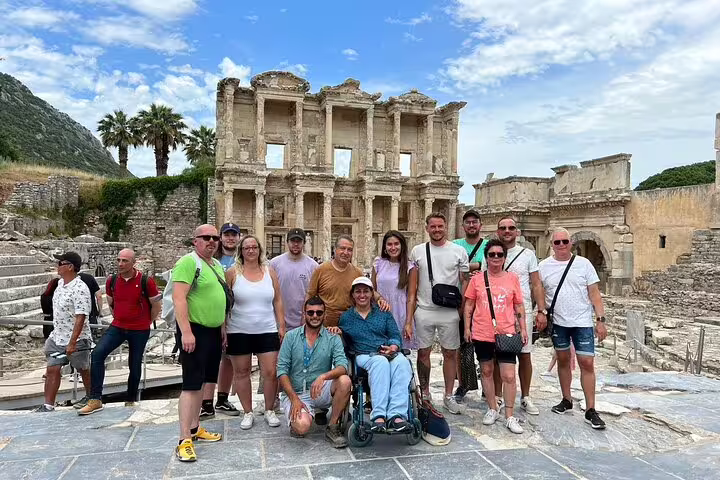 Group of tourists at Ephesus Library during a day tour with flights from Istanbul, enjoying a sunny historical exploration.
