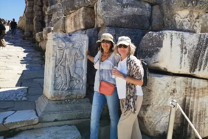 Visitors by marble relief at Ephesus ruins, private guided tour for cruise passengers with skip-the-line entry