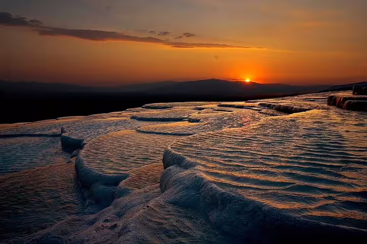 Breathtaking sunset over Pamukkale's travertine terraces, ideal for a memorable Ephesus and Pamukkale day tour.