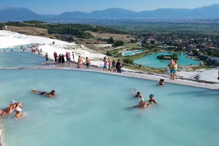 Tourists enjoying thermal pools with scenic views at Pamukkale during the Ephesus & Pamukkale Tour from Istanbul.