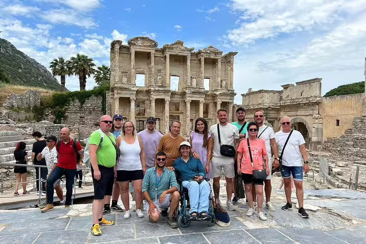 A group enjoys the ancient ruins of Ephesus on a skip-the-line private tour from Kusadasi Port, with clear blue skies.