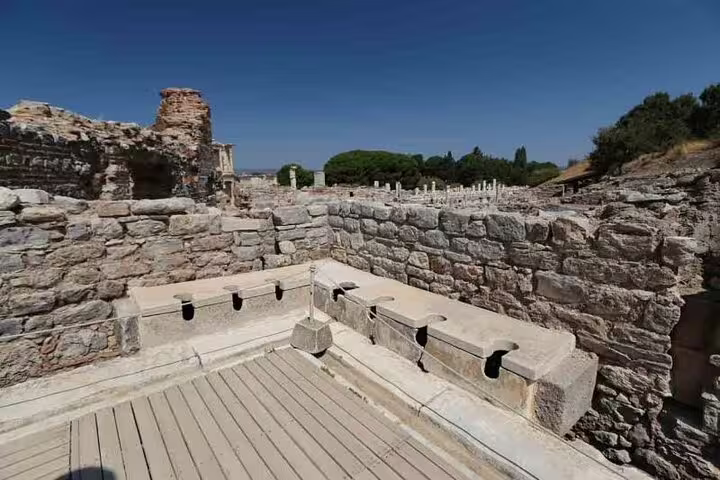 Ancient stone latrines at Ephesus, showcasing Roman engineering on a private tour from Izmir Port.