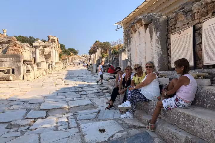Small group resting on Curetes Street in ancient Ephesus ruins during guided tour with lunch and transfers