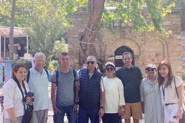 Tour group enjoying a visit to the House of the Virgin Mary, surrounded by lush greenery on an Ephesus excursion.