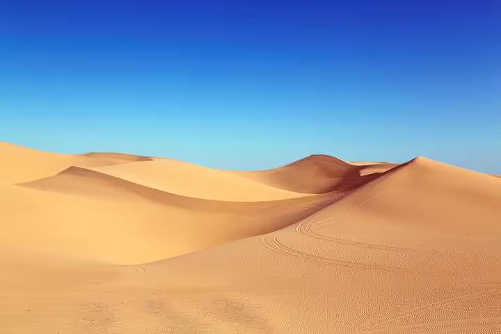 Golden Erg Chebbi dunes under clear blue sky on 3-day Marrakech to Sahara desert tour in Morocco