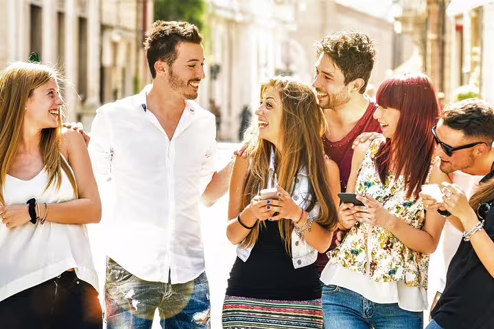 Friends using smartphones on a self-guided e-scavenger hunt in Maastricht, exploring city streets at their own pace