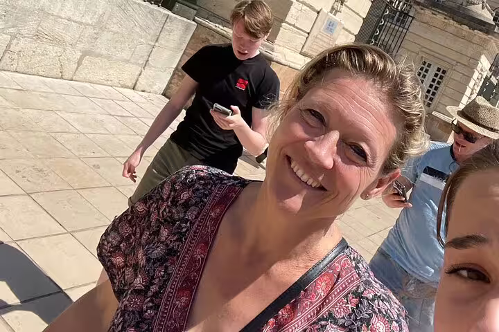 Smiling participants follow clues on phones in old town Nancy during a self-guided e-scavenger hunt walking tour