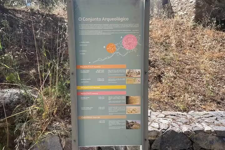 Outdoor archaeological information board at Escoural Caves listing historical periods for guided tours in Montemor-o-Novo.