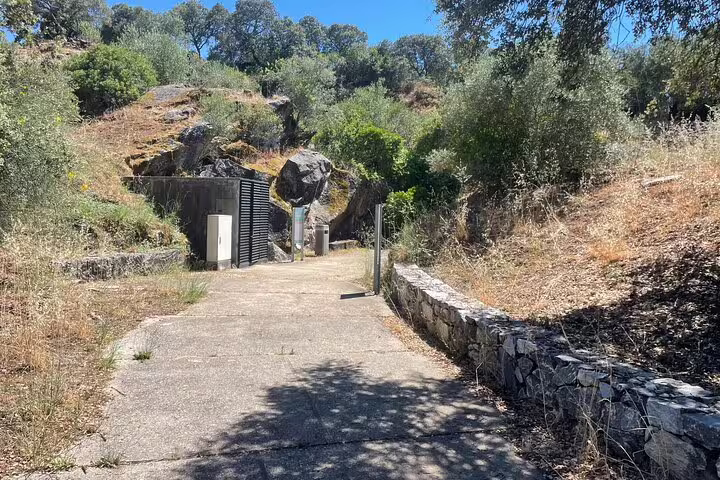 Entrance to Escoural Caves surrounded by lush greenery, offering a serene start to a guided tour in Évora.