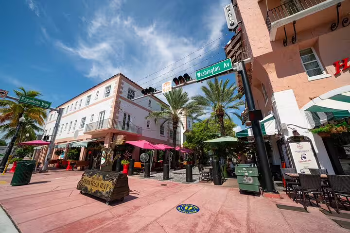 Española Way and Washington Ave intersection with colorful outdoor cafes and palm trees in Miami Beach