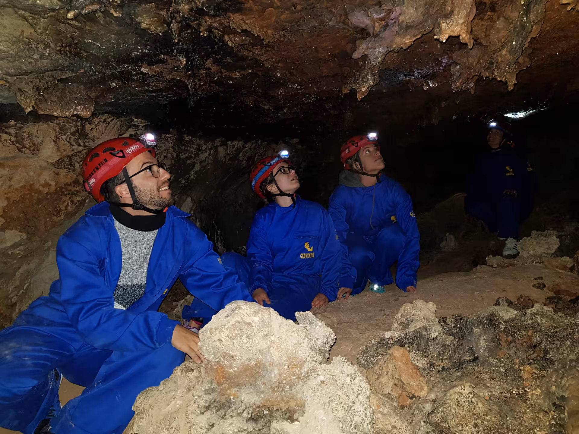 Grupo en ruta de espeleología de iniciación en Ejulve, Teruel, con cascos y frontales en cueva