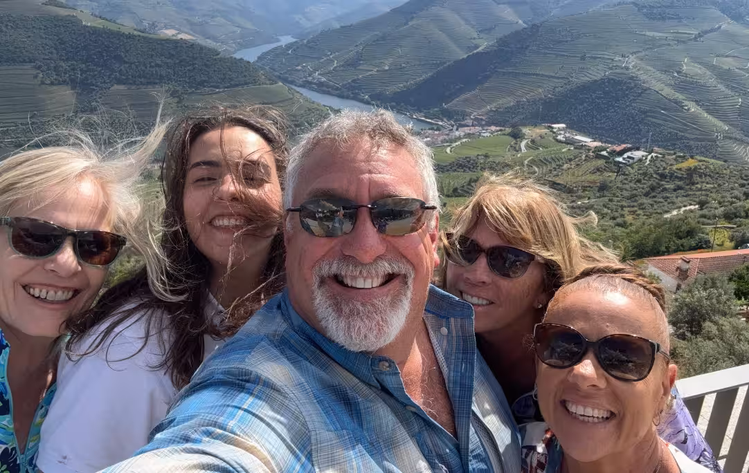 Group selfie at Douro Valley viewpoint on Essence Tour, with terraced vineyards and river panorama in Portugal