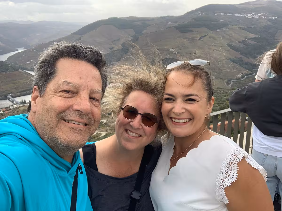Essence Tour guests selfie at Douro Valley viewpoint with river and terraced vineyards, Portugal day trip