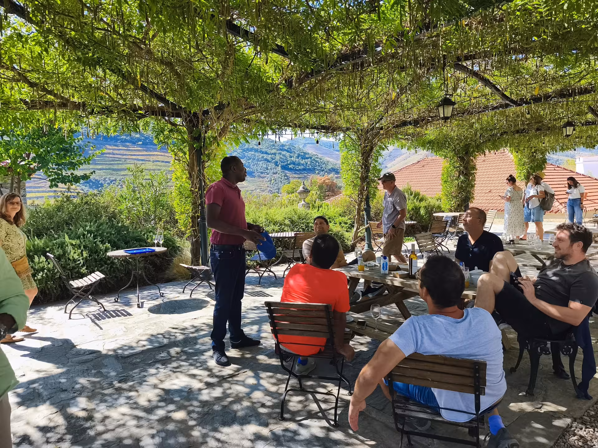 Essence Tour winery terrace briefing under vine pergola with Douro Valley views and relaxed tasting