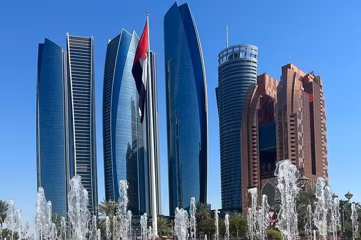 Etihad Towers skyline with UAE flag and fountains, iconic photo stop on Abu Dhabi city tour Corniche