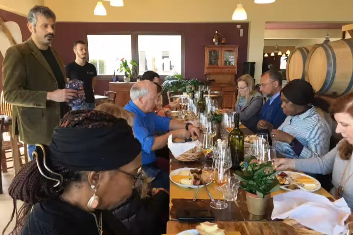Guests enjoying winery tasting with Sicilian appetizers and wine during Etna and Taormina day trip from Siracusa