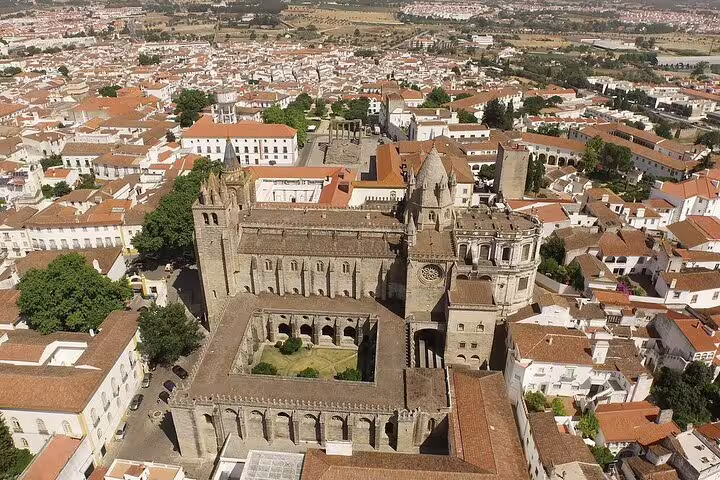 Aerial view of Évora showcasing its historic architecture and iconic cathedral amidst a sprawling cityscape.