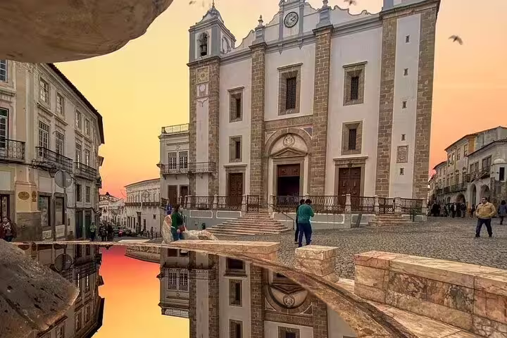 Historic Évora cityscape at sunset, capturing a stunning reflection of the church on a tranquil full-day tour from Lisbon.