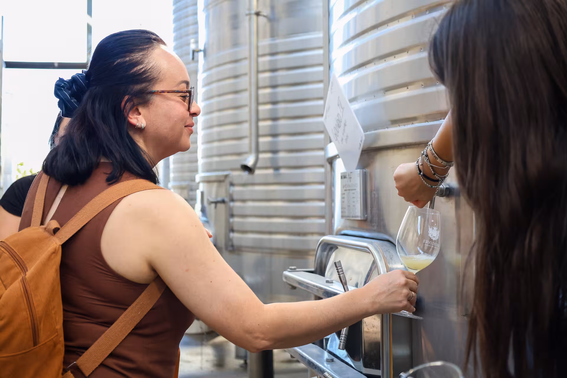 Tour participants enjoy wine tasting from steel tanks at a winery in Alentejo during the Évora wine tour.