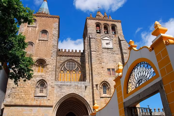 Majestic façade of Évora Cathedral under a vibrant blue sky, showcasing its Gothic architecture and historic charm.