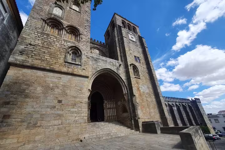 Medieval architecture of Évora Cathedral under a blue sky, featured in the Évora and Monsaraz small-group day tour from Lisbon.