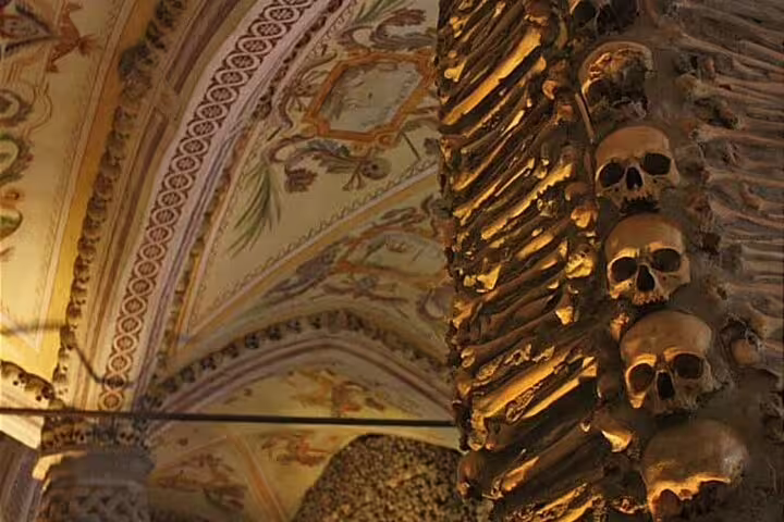 Explore the Chapel of Bones in Évora, featuring ornate arches and skull-lined walls, on a full-day Alentejo wine tour.