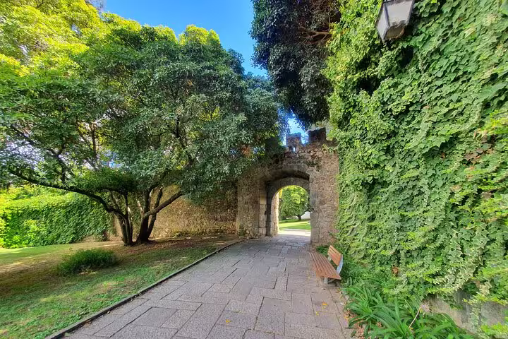 Historic stone archway surrounded by lush greenery in Évora, Portugal, part of the Evora & Monsaraz private full-day tour.
