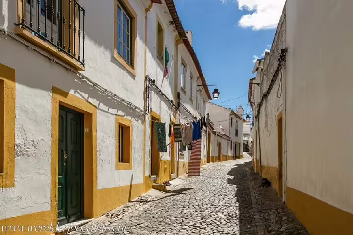 Cobblestone lane in Evora old town with whitewashed houses, ideal for a self-guided GPS audio tour