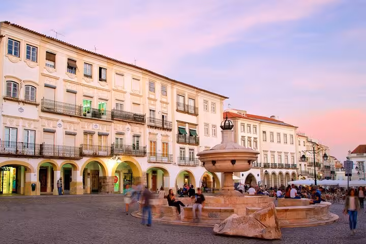 Sunset view of Praça do Giraldo in Évora with historic buildings and a lively atmosphere, perfect for a private walking tour.